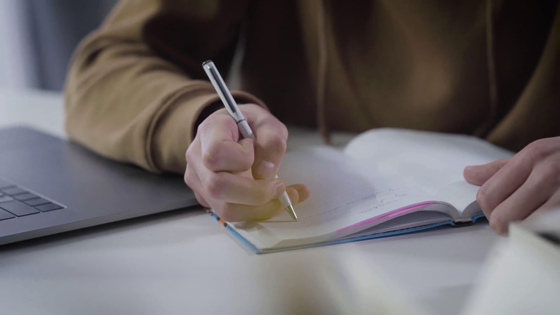 Student revising for GCSE science exams with textbooks and notes